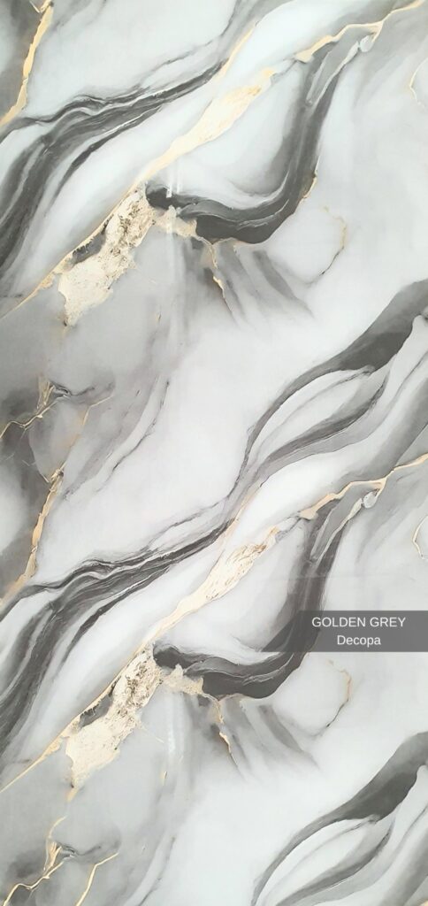 PVC Mermer Panel Golden Grey modeli, gri mermer zemin üzerinde akışkan altın damar detaylarına sahip dekoratif PVC duvar panelidir. Modern ve lüks iç mekân dekorasyonlarında TV ünitesi arkası, salon, ofis, banyo, mutfak, otel ve showroom duvar kaplamalarında kullanılan estetik mermer görünümlü PVC panel çözümüdür. Parlak ve silinebilir yüzeyi, suya dayanıklı PVC-polimer yapısı ve modern damar geçişleri sayesinde uzun ömürlü kullanım sunar. Golden Grey deseni, mekânlara modern gri tonlarıyla birleşen premium gold detaylar ve güçlü bir mimari görünüm kazandırır.PVC Mermer Panel Golden Grey – Gold Damar Geçişli Gri Mermer Paneli